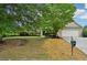 Charming one-story home with manicured lawn, mature tree, two-car garage, and a front yard view at 6027 Windfall Ct, Powder Springs, GA 30127