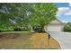 Traditional-style home featuring a two-car garage, manicured lawn, and mature landscaping at 6027 Windfall Ct, Powder Springs, GA 30127