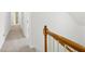 Upstairs hallway featuring neutral carpet, white walls, and wooden banister at 6027 Windfall Ct, Powder Springs, GA 30127