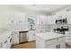 Well-equipped kitchen featuring stainless appliances, quartz countertops, white cabinets, an island, and modern finishes at 6027 Windfall Ct, Powder Springs, GA 30127