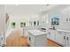 Bright, open kitchen features a center island, quartz countertops, stainless appliances, and views of the living room at 6027 Windfall Ct, Powder Springs, GA 30127