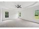 Spacious main bedroom with a tray ceiling, ceiling fan, plush carpeting, and lots of natural light at 6027 Windfall Ct, Powder Springs, GA 30127