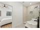 Modern bathroom featuring double sinks, decorative tile shower, and view into the bedroom at 1355 Lockwood Sw Dr, Atlanta, GA 30311