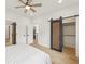 Open bedroom with sliding barn door, modern fan, and access to the ensuite and closet at 1355 Lockwood Sw Dr, Atlanta, GA 30311