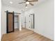 Bright bedroom with wood floors, closet with a sliding barn door, and en suite bathroom at 1355 Lockwood Sw Dr, Atlanta, GA 30311