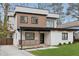A modern two-story home with a combination of white brick and brown siding, featuring a charming front porch at 1355 Lockwood Sw Dr, Atlanta, GA 30311