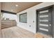Cozy front porch with wood flooring, a modern black door, and a view of the surrounding landscape at 1355 Lockwood Sw Dr, Atlanta, GA 30311