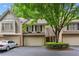 Charming townhome featuring a brick facade, attached garage, and lush landscaping at 2908 Woodruff Se Dr, Smyrna, GA 30080
