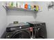 Modern laundry room with two front-load Samsung washers and upper shelf storage at 2908 Woodruff Se Dr, Smyrna, GA 30080