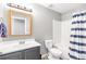 Bathroom featuring a shower/tub combo with curtain, toilet and single sink vanity at 1194 Grandview Cir, Powder Springs, GA 30127