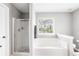 Relaxing bathroom with a soaking tub, a separate glass-enclosed shower, and a bright window at 1194 Grandview Cir, Powder Springs, GA 30127