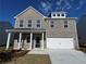 Charming two-story home with a grey brick exterior, covered porch, and attached two-car garage at 1640 Tide Mill Rd, Cumming, GA 30040