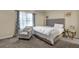 Bedroom features a bed with a tufted headboard, window, and a sitting chair at 4581 Sagebrush Ct, Snellville, GA 30039