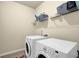 Functional laundry room featuring modern washer and dryer with a storage shelf at 4581 Sagebrush Ct, Snellville, GA 30039
