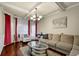 Inviting living room with hardwood floors, tray ceilings, elegant chandelier, and comfortable seating arrangement at 4581 Sagebrush Ct, Snellville, GA 30039
