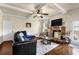 Cozy living room with hardwood floors, a stone fireplace, and a ceiling fan for added comfort at 4581 Sagebrush Ct, Snellville, GA 30039