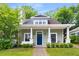 Charming home with a covered front porch, lush landscaping, and a blue front door at 212 Haralson Ne Ave, Atlanta, GA 30307