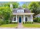 Charming home with lush green lawn, front porch and walkway to front door at 212 Haralson Ne Ave, Atlanta, GA 30307
