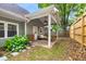 Covered back patio with comfortable seating and view of the fenced backyard and landscaping at 212 Haralson Ne Ave, Atlanta, GA 30307