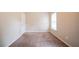 Standard bedroom with tan walls, plush carpeting, a single door, and window at 297 Edison Dr, Stockbridge, GA 30281