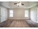 Neutral-colored main bedroom features carpeting, ceiling fan, tray ceiling, and two windows at 297 Edison Dr, Stockbridge, GA 30281