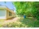 Side yard view of a light colored home with an attached side yard featuring trees and healthy grass at 297 Edison Dr, Stockbridge, GA 30281
