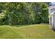 Grassy backyard bordered by mature trees, offering privacy at 3534 Oakshire Se Way, Atlanta, GA 30354