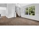 Bright living room with large window, neutral carpet, staircase, and white trim at 3534 Oakshire Se Way, Atlanta, GA 30354