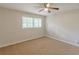 This bedroom features neutral walls, carpeted floor, a ceiling fan, and bright natural light from a window at 3661 Boring Rd, Decatur, GA 30034