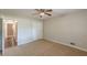 This bedroom features neutral walls, carpeted floor, a ceiling fan, and a view of the hall through the bedroom door at 3661 Boring Rd, Decatur, GA 30034