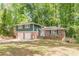 Charming two-story brick home with an attached two-car garage, mature trees, and manicured lawn at 3661 Boring Rd, Decatur, GA 30034
