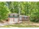 Split-level home with a brick facade and a two-car garage nestled among mature trees at 3661 Boring Rd, Decatur, GA 30034