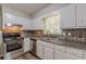 Updated kitchen with stainless steel appliances, tile backsplash, double sink, and white cabinets at 3661 Boring Rd, Decatur, GA 30034