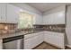 Classic kitchen featuring white cabinets, tiled backsplash, updated appliances and stainless steel dishwasher at 3661 Boring Rd, Decatur, GA 30034