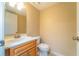 Bathroom featuring oak vanity with modern faucet, a toilet, and a mirror, with an open door view at 3677 Blackshear Ct, Duluth, GA 30096