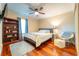 Bedroom features a bed, desk, hardwood flooring, ceiling fan, and a window overlooking the backyard at 3677 Blackshear Ct, Duluth, GA 30096