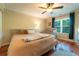 Bedroom featuring a king bed, wood flooring, ceiling fan, and a window overlooking the backyard at 3677 Blackshear Ct, Duluth, GA 30096