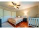 Bedroom features king bed, wood floors, ceiling fan, and closet doors; baby furniture included at 3677 Blackshear Ct, Duluth, GA 30096