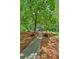 Beautiful backyard walkway leading to a gazebo and lush landscape with a canopy of mature trees at 1275 Fontainebleau Ct, Lawrenceville, GA 30043