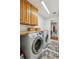 Laundry room with wooden cabinets, countertop, and modern Samsung washer and dryer at 1275 Fontainebleau Ct, Lawrenceville, GA 30043