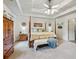 Spacious main bedroom boasts a trey ceiling, a decorative four-poster bed, and a side table at 1275 Fontainebleau Ct, Lawrenceville, GA 30043