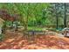 Back patio with outdoor seating surrounded by lush landscaping and mature trees at 1275 Fontainebleau Ct, Lawrenceville, GA 30043