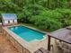 Private backyard pool surrounded by lush greenery, gazebo with outdoor seating, and charming pool house at 1275 Fontainebleau Ct, Lawrenceville, GA 30043
