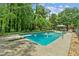 Large pool area with diving board, lighting, and mature trees at 1275 Fontainebleau Ct, Lawrenceville, GA 30043