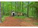 Small storage shed surrounded by a lush and overgrown forest, perfect for an outdoor workshop at 1275 Fontainebleau Ct, Lawrenceville, GA 30043