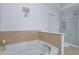 Inviting bathroom featuring a luxurious soaking tub and shower with neutral-toned tile and modern glass doors at 2003 Burns View Ln # 2, Lawrenceville, GA 30044