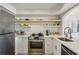 Modern kitchen with stainless steel appliances, white cabinets, and open shelving with the kitchen sink at 2870 Pharr Court South Nw # 2404, Atlanta, GA 30305