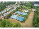 Aerial view of the community tennis courts, pool, and clubhouse, surrounded by lush greenery at 333 Gardens Of Harmony Dr, Canton, GA 30115