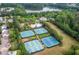 Aerial view showcases community tennis courts, pool, and homes nestled among the trees at 333 Gardens Of Harmony Dr, Canton, GA 30115