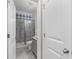 Modern bathroom featuring a tiled shower with glass doors, complemented by gray cabinets at 333 Gardens Of Harmony Dr, Canton, GA 30115